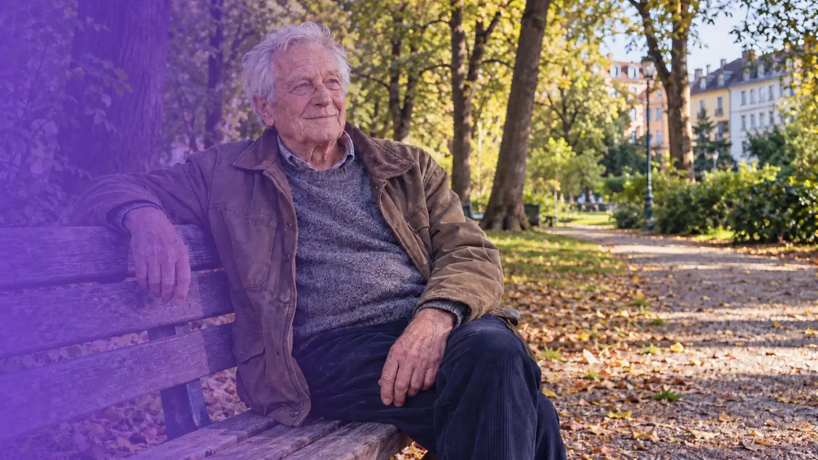 Umirovljenik sjedi na klupi u njemačkom parku